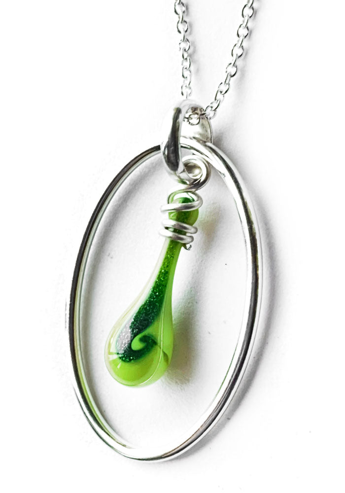 A swirl of dark glittering green adds to the striking lime green of this silver oval and glass teardrop necklace